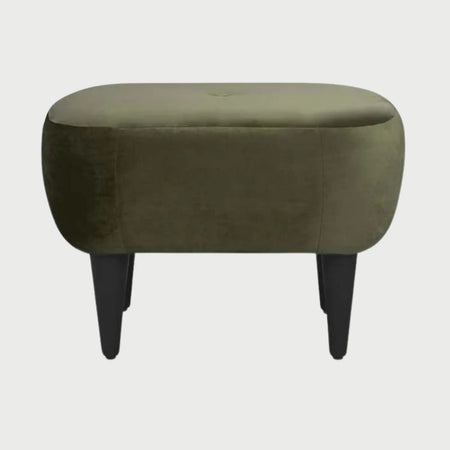 Vista frontal del taburete Tavari en color gris neutro, resaltando su forma orgánica y el contraste sutil del capitoné central con las patas oscuras.